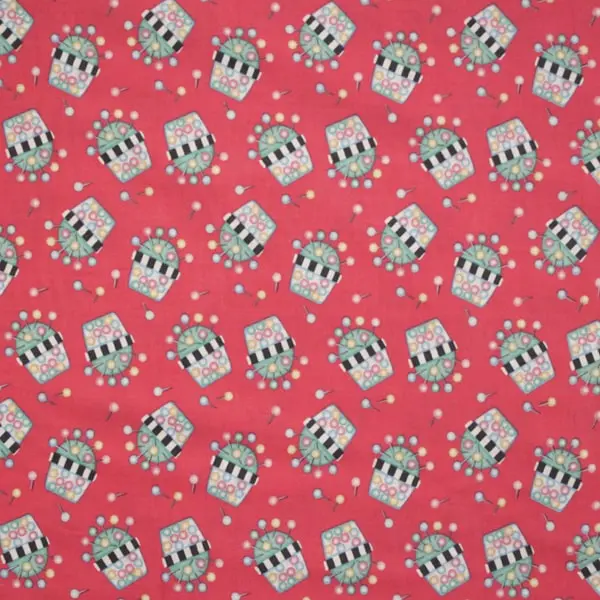 Tela estampada con alfileteros de diferentes colores sobre fondo coral