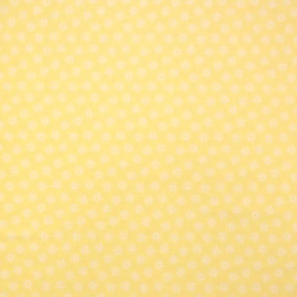 Tela en color amarillo estampada con soles de color blanco