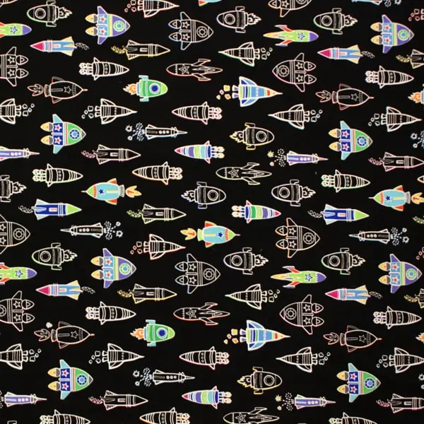 Tela fondo negro con estampado de naves de colores que brillan en la oscuridad