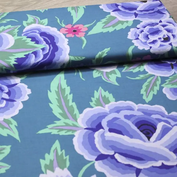 Tela de algodón Kaffe Fassett Embroidered Shawl azul con flores y hojas de 110cm - Vista del lomo enrollado