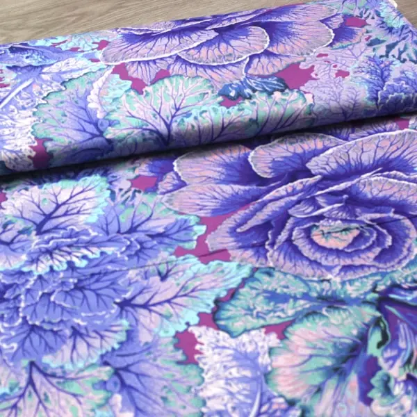 Algodón patchwork Kaffe Fassett Curly Kale Blue flores lavanda y fucsia de 110cm - Vista del lomo enrollado